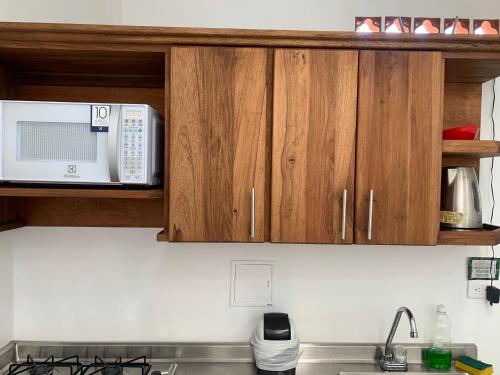 a kitchen with a microwave and a stove top oven at Aloja-T en Apartamento amoblado SIN balcón en Ciudad Bolivar in Ciudad Bolívar