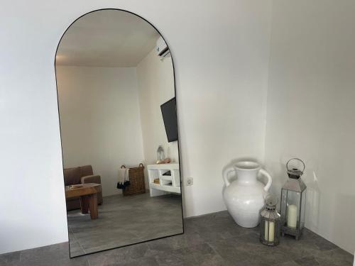 a mirror in a room with a vase and a table at Cabana in Gili Air