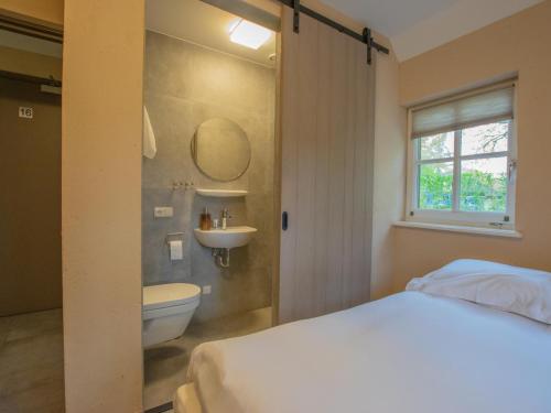 een slaapkamer met een bed, een wastafel en een toilet bij Jager en Hooijmijt in Gouwelaar