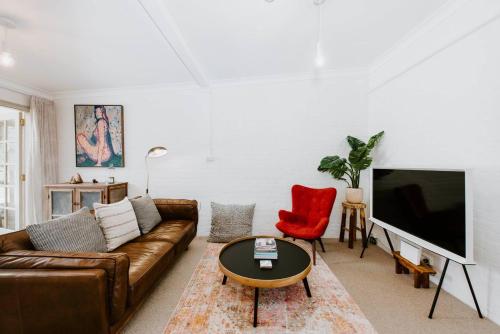 a living room with a couch and a tv at Riddell Cottage - A Federation Hideaway in Town in Mudgee