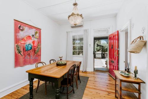 a dining room with a wooden table and chairs at Riddell Cottage - A Federation Hideaway in Town in Mudgee