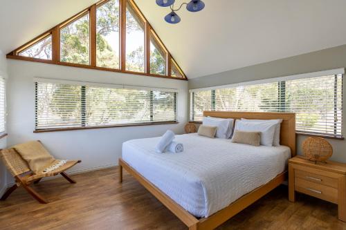a bedroom with a large bed and windows at Casa Rua Margaret River in Witchcliffe