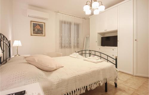 biała sypialnia z łóżkiem i telewizorem w obiekcie Awesome Apartment In Quartu Santelena With Kitchen w mieście Quartu SantʼElena