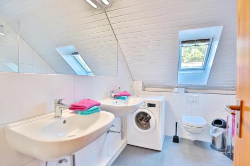a bathroom with a sink and a washing machine at Ferienhaus Seeweg 17 Ferienhaus Seeweg 17 in Schürsdorf