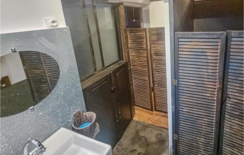 La salle de bains est pourvue d'un lavabo et d'un miroir. dans l'établissement 1 Bedroom Beautiful Home In Lhoumeau, à LʼHoumeau
