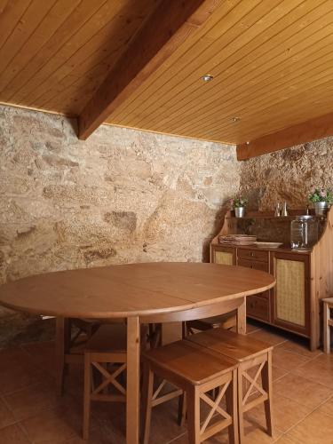 a wooden table in a kitchen with a wooden ceiling at Casa do Soito. in Avelãs de Ambom