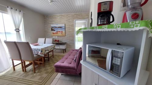 cocina y sala de estar con sofá y microondas en Casa Beira Mar Mariscal Superior, en Bombinhas