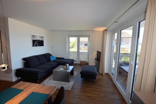sala de estar con sofá y mesa en Meeresblick "Heimathafen 3.9" - Haus 3, WE 39 en Hohwacht