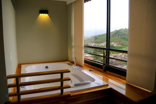 a large bath tub in a room with a large window at Hotel Entre Brumas in Aguadas