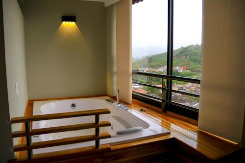 a large bath tub in a room with a large window at Hotel Entre Brumas in Aguadas