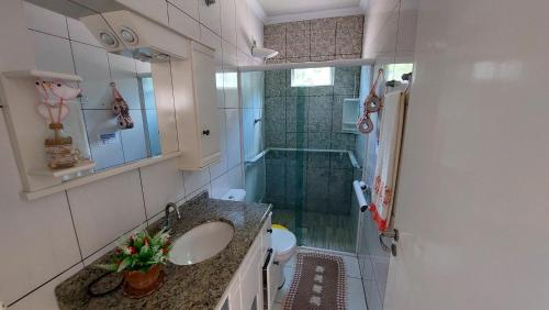 y baño con ducha, lavabo y bañera. en Casa Beira Mar Mariscal Terreo en Bombinhas