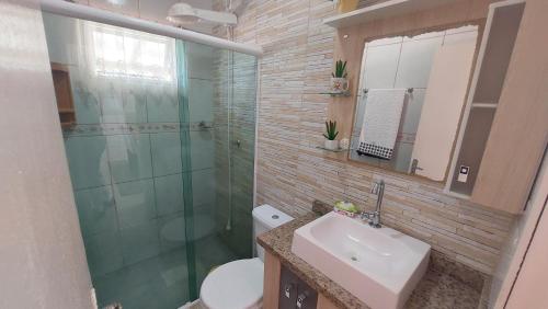 a bathroom with a sink and a shower and a toilet at Casa Beira Mar Mariscal 1 in Bombinhas