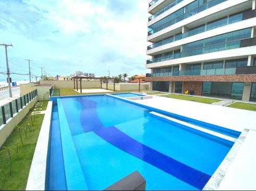 una gran piscina frente a un edificio en Salvador - Praia do Flamengo - Pé na areia, en Salvador