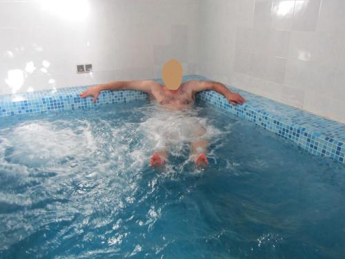 un homme flottant dans une piscine dans l'établissement KEUR DIAM - Maison de la Paix, à Saly Portudal