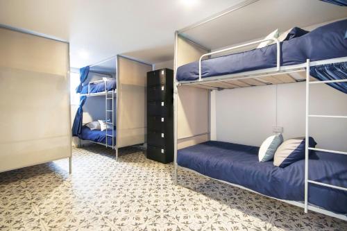 two bunk beds in a room with blue beds at Urbana Hostel in Bogotá