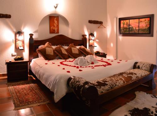 a bedroom with a large bed with red roses on it at Hotel Antonio Nariño in Villa de Leyva