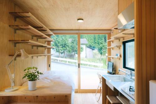 a tiny house with a large window and a desk at 安全第一客室 Anzen Daiichi INN in Nishiawakura