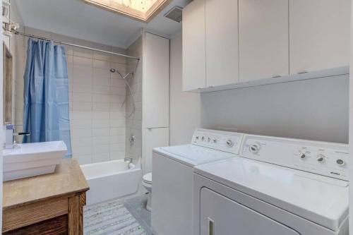 a white bathroom with a sink and a washing machine at FUNCTIONAL AND COZY APARTMENT - CITE LIMOILOU in Quebec City