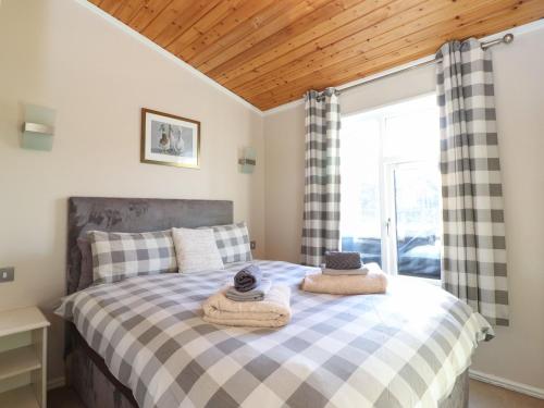 sypialnia z łóżkiem z ręcznikami w obiekcie Brightwater Lodge w mieście Windermere