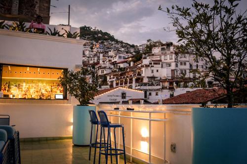 a bar with chairs and a view of a city at William Hotel Boutique De Diseño in Taxco de Alarcón
