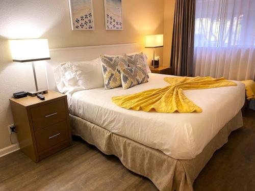 a hotel room with a bed with a yellow blanket on it at Beautiful Ocean Views - SEASCAPE - Hot Tubs - Heated Pools - Cozy Fireplace in Aptos