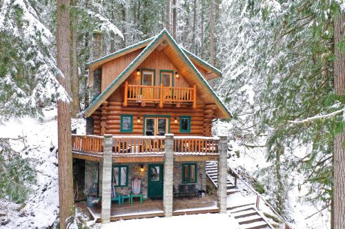 a log cabin in the woods in the snow at ArborMyst in Glacier