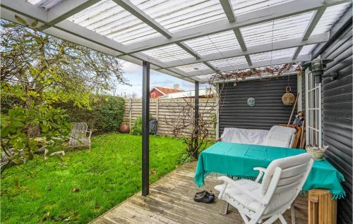 a patio with a table and chairs and a pergola at Gorgeous Home In Karrebæksminde in Karrebæksminde
