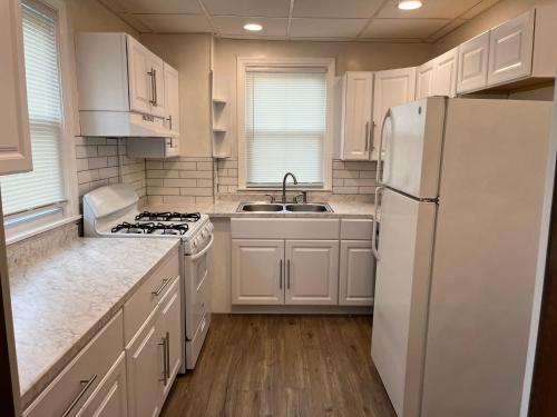 cocina con armarios blancos y nevera blanca en Hudson #1 Private Two Bed near Xavier & Downtown en Cincinnati