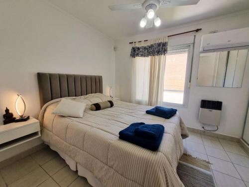 Paraná Confort في بارانا: غرفة نوم بسرير كبير عليها مناشف زرقاء