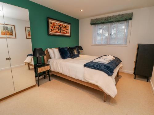 a bedroom with a bed and a green wall at A Stone's Throw in Torpoint