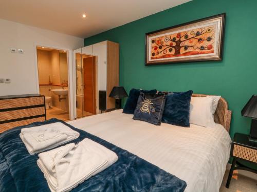 a bedroom with a large bed with blue walls at A Stone's Throw in Torpoint
