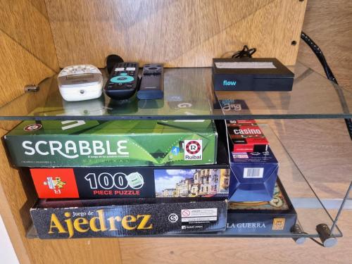 a glass shelf with games and other items on it at Paraná Confort in Paraná