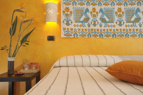 a bedroom with a bed and a painting on the wall at Le Stanze di Patika in Tortolì