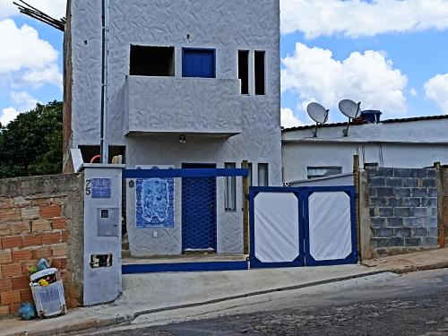 ein Gebäude mit einer blauen und weißen Tür auf einer Straße in der Unterkunft D'Santos Hospedaria. Aconchego perto de Tiradentes in Coroas
