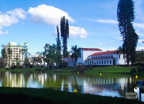 a lake in front of a building and a building at Casa em São Lourenço-MG in São Lourenço