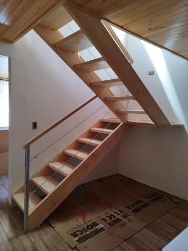 an attic room with a wooden staircase in a house at Hermosa casa a pasos de la playa, excelente vista. in Pichilemu