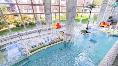 an indoor swimming pool in a large building with a water slide at Kamenoi Hotel Aso Park Resort in Aso