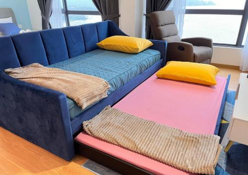 Sofá azul con 2 cojines y 2 alfombras en Comfy Imperium Residence Kuantan Studio Seaview en Kuantan