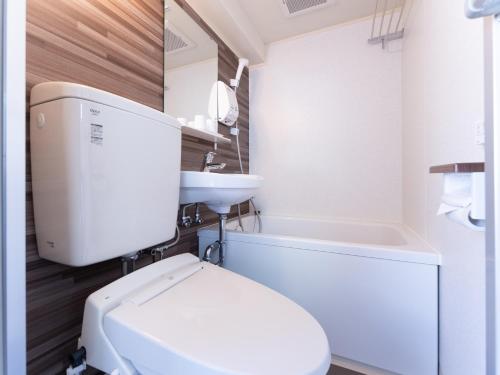 Łazienka z białą toaletą i umywalką w obiekcie Chang Tee Hotel Ikebukuro w Tokio