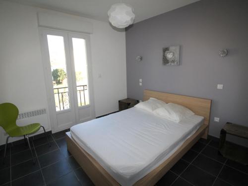 バニュルス・シュル・メールにあるAppartement Banyuls-sur-Mer, 3 pièces, 4 personnes - FR-1-309-4のベッドルーム(白いベッド1台、緑の椅子付)