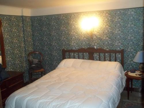 um quarto com uma cama branca e uma luz na parede em Appartement Banyuls-sur-Mer, 3 pièces, 6 personnes - FR-1-309-35 em Banyuls-sur-Mer