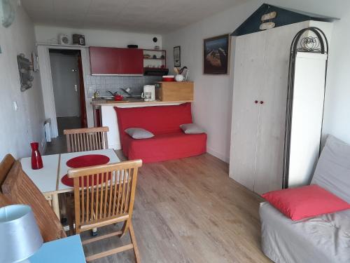 un salon avec un canapé rouge et une cuisine dans l'établissement Appartement avec Piscine et Parking Privé - Arcachon, Port de Plaisance - FR-1-319-93, à Arcachon