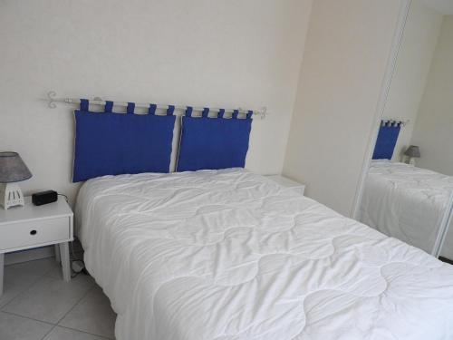 レ・サ​​ーブル・ドロンヌにあるAppartement Les Sables-d'Olonne, 2 pièces, 3 personnes - FR-1-92-779のベッドルーム(白いベッド1台、青いカーテン付)