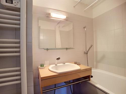 a bathroom with a sink and a mirror and a tub at Appartement Les Gets, 2 pièces, 4 personnes - FR-1-454-26 in Les Gets