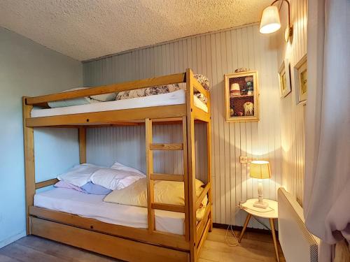 a bedroom with a bunk bed with white sheets at Appartement Les Gets, 2 pièces, 4 personnes - FR-1-454-26 in Les Gets