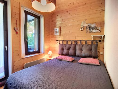 レ・ジェにあるAppartement Les Gets, 2 pièces, 4 personnes - FR-1-454-33の木造キャビン内のベッド1台が備わるベッドルーム1室を利用します。