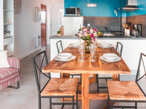 une salle à manger avec une table et des chaises en bois dans l'établissement Appartement T3 avec Terrasse à 30m des Commerces et Plage à Ploemeur - FR-1-349-72, à Ploemeur