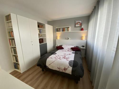 une chambre avec un lit et des étagères dans l'établissement Ploemeur - Appartement 3 pièces avec balcon, ascenseur et WIFI près de la plage - FR-1-349-90, à Ploemeur