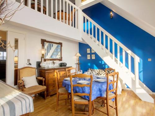 - une chambre aux murs bleus et un escalier avec une table et des chaises dans l'établissement Duplex 5 pièces avec balcon à 30m de la plage - 7 couchages, acceptant animaux, wifi et parking - FR-1-349-114, à Ploemeur