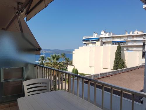 d'un balcon avec une table et des chaises ainsi qu'un bateau de croisière. dans l'établissement Studio Climatisé 2/3 Pers - Proche Plage et Commerces - Wifi Gratuit - FR-1-466A-18, à Saint-Raphaël